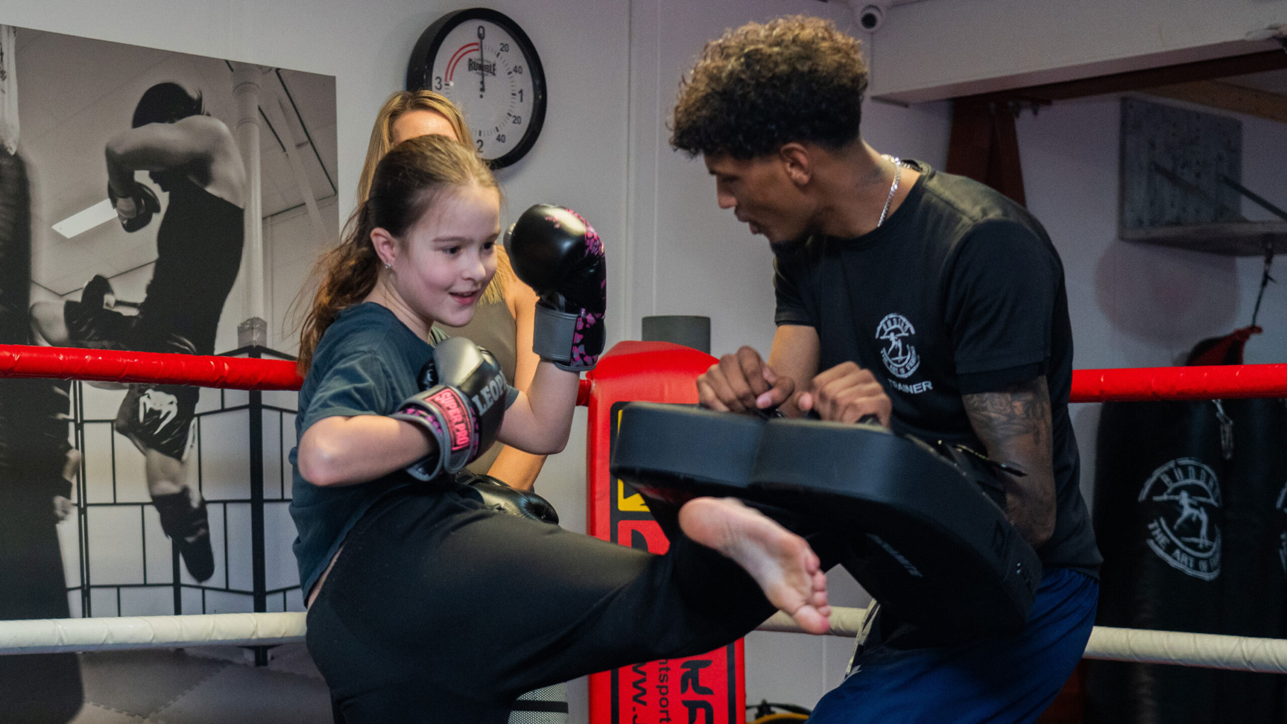 Jongedame traint samen met een kickboks trainer in de boksschool